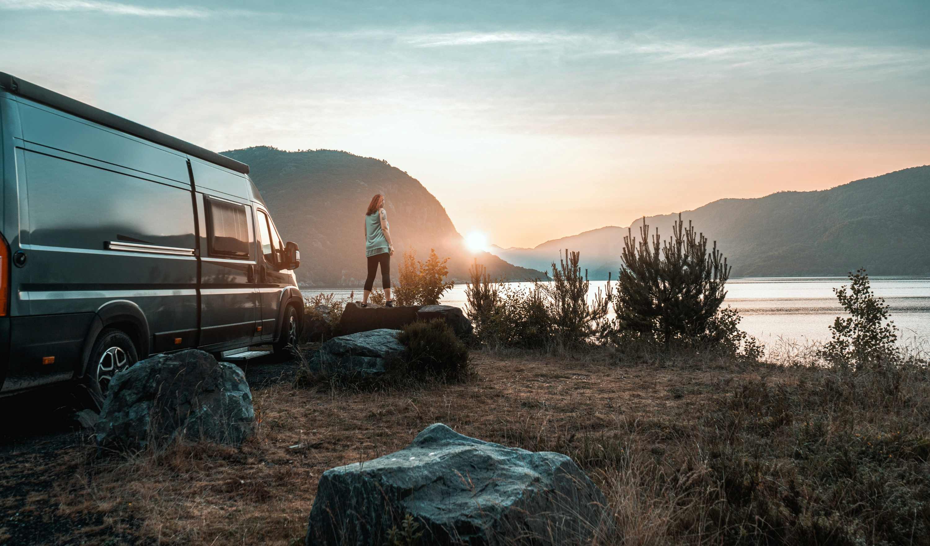 converted camper van parked next to a lake